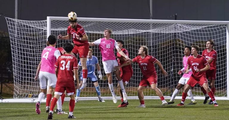 Player heading the ball at a soccer match.