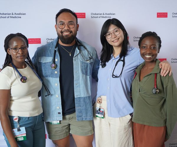 Medical students posing in front of a Boston University School of Medicine backdrop.