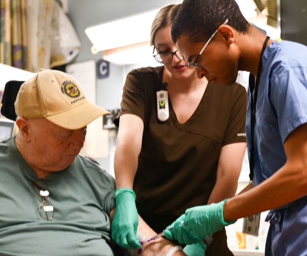 Medical staff performing a procedure on an elderly patient