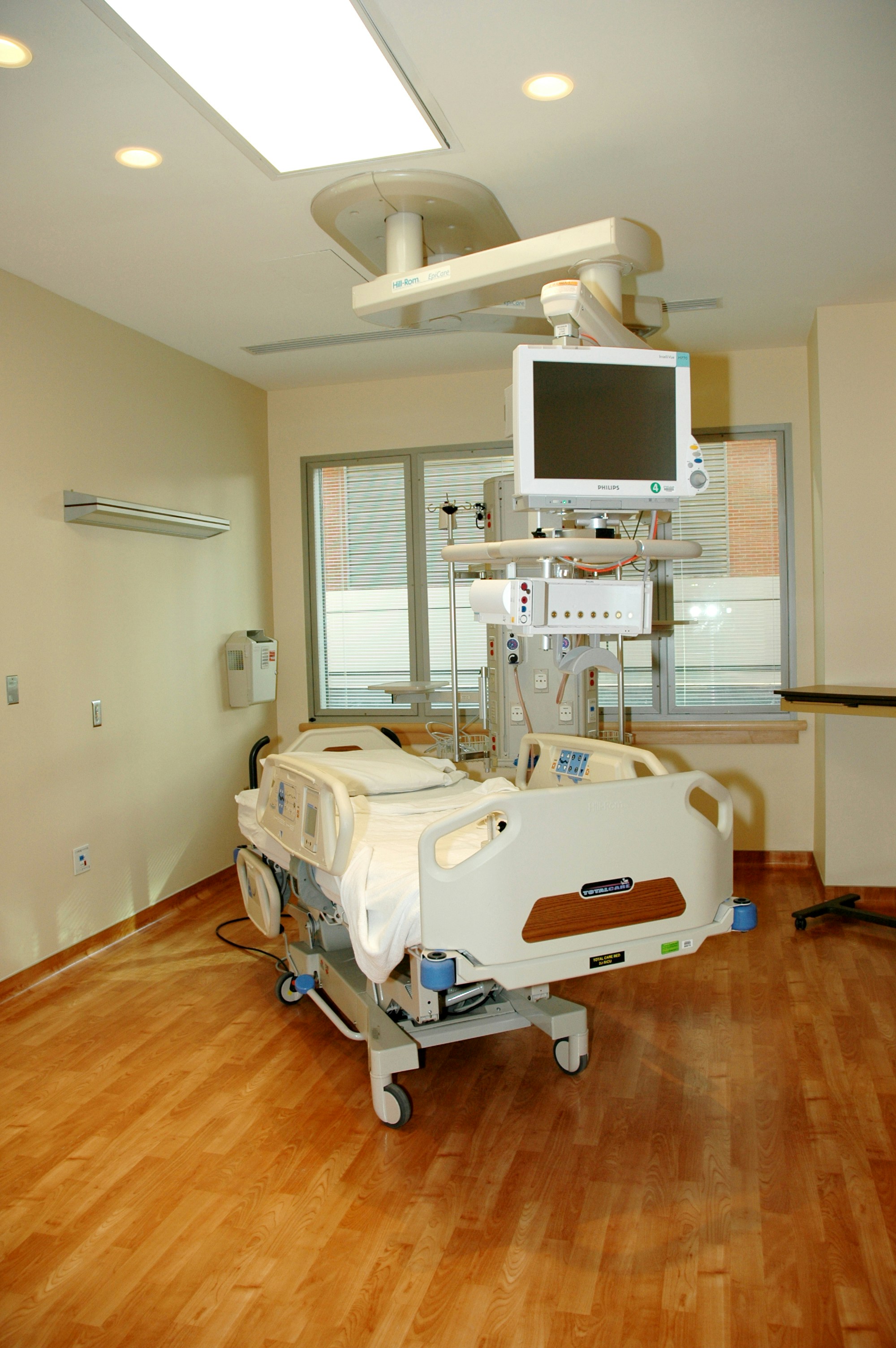 hospital room with white bbed near white wall and window