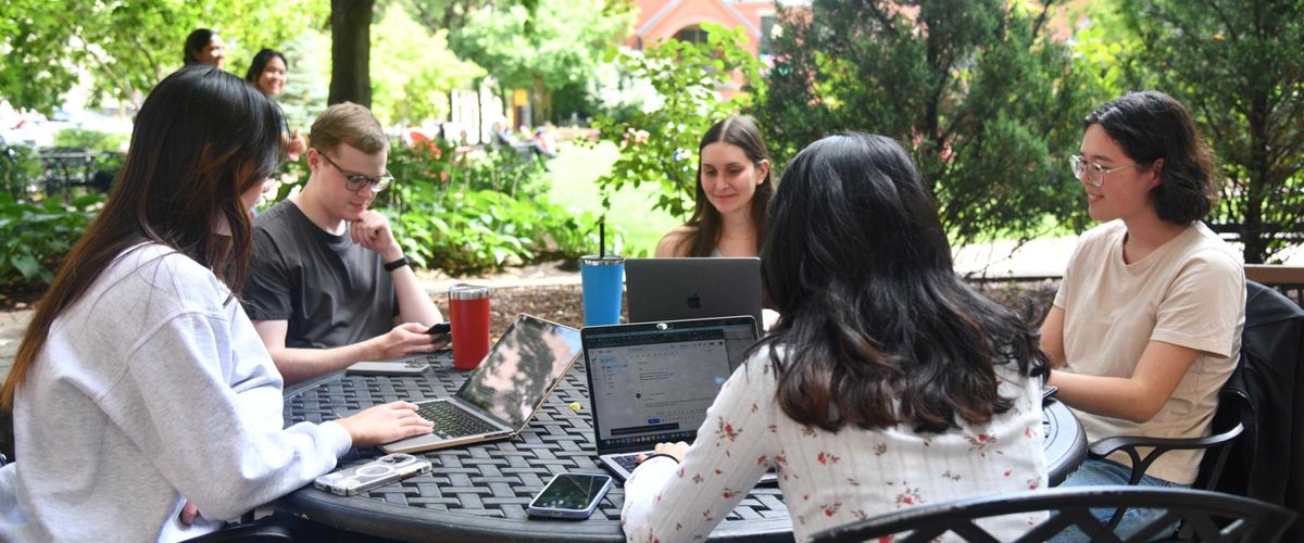 Students studying outside on their laptops