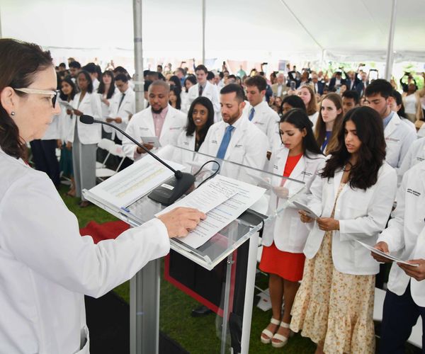 Heather Miselis leading hippocratic oath to students on whitecoat day.