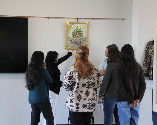 Photo of people pointing to artwork