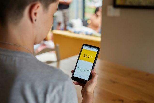 Person looks at high blood glucose (blood sugar) results on CGM app screen.