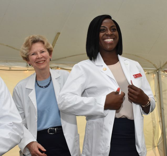 Dean Antman congratulates first-year medical student Nneoma Duru (now MD) at the 2018 White Coat Ceremony.
