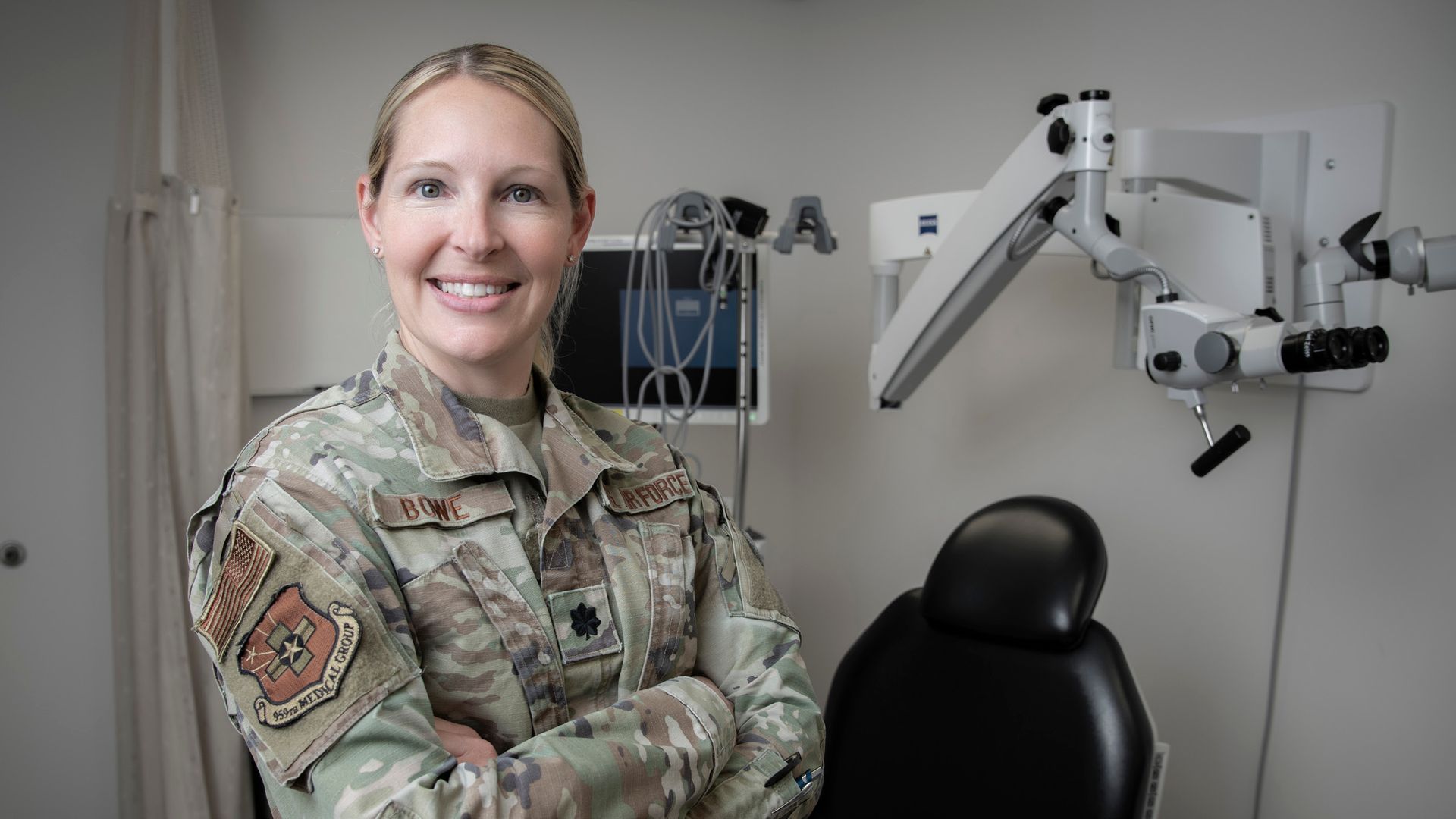 Lt. Colonel Sarah Bowe, MD (CAMED'08) stands proudly in uniform with medical equipment in the background.