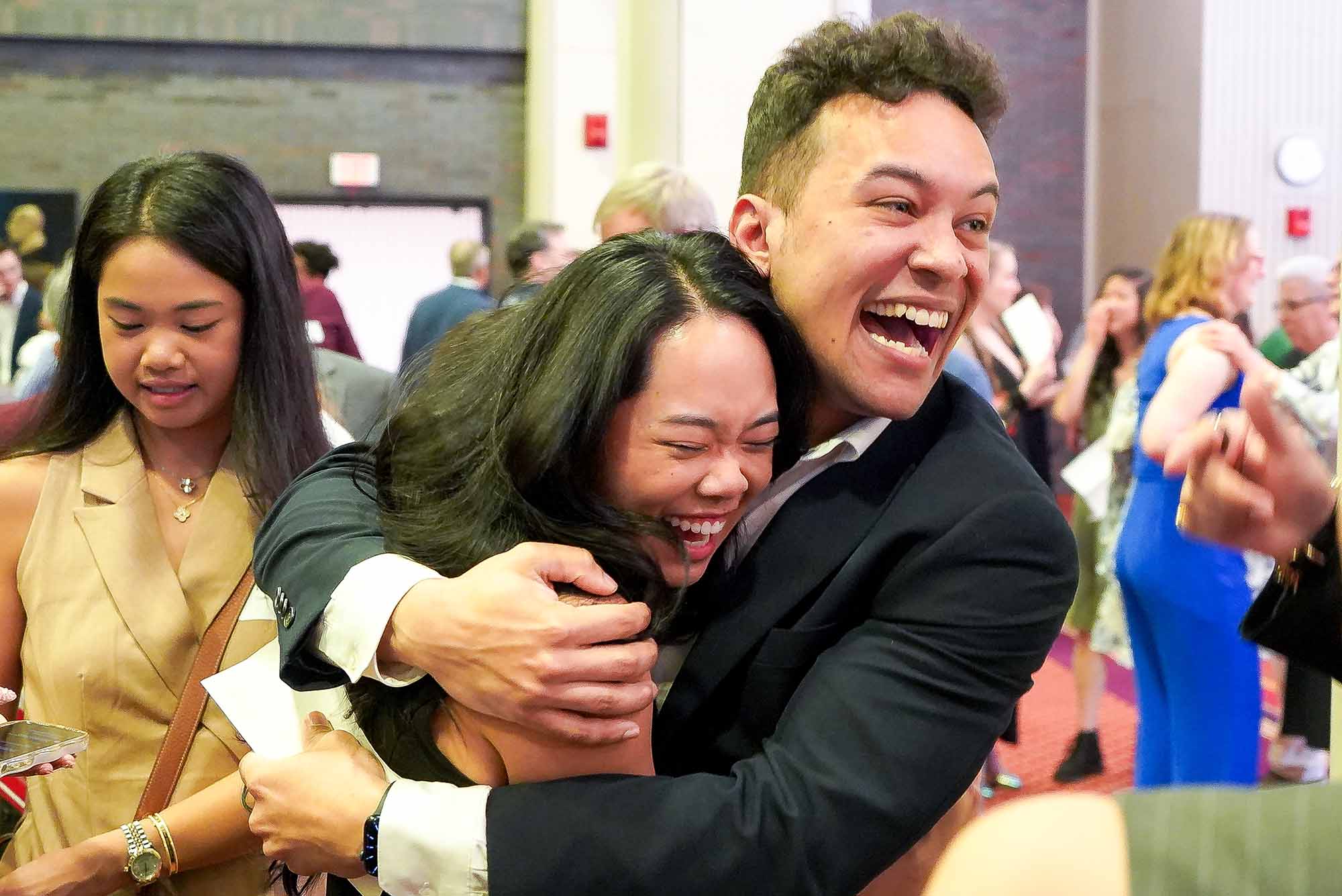 Man Hugs Woman after recieving Match Day Envelope