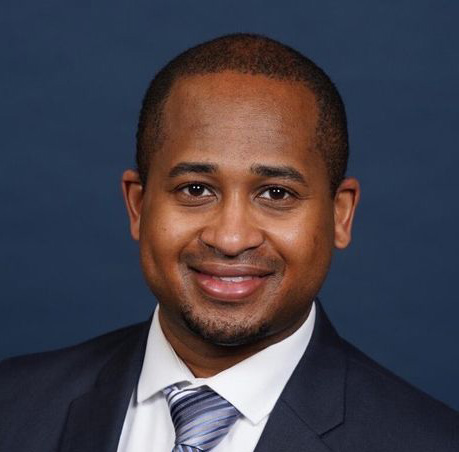 Dennis Jones, a black man in a suit smiling