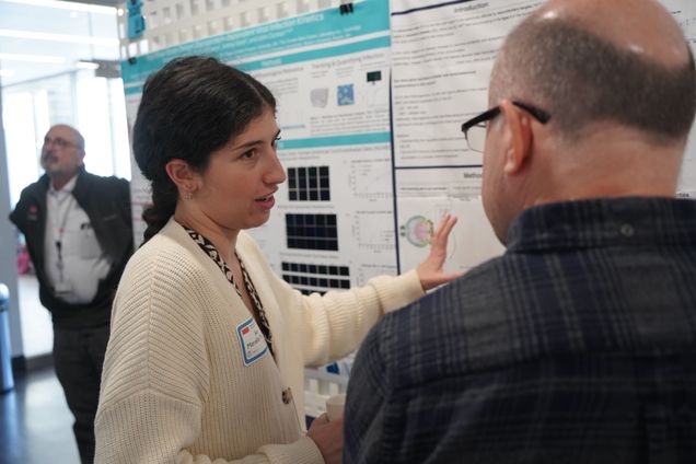 student explaining poster to faculty member