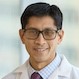 Head and shoulders image of Gene Kwan wearing white coat, eyeglasses