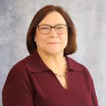 portrait of Laura Anastasi wearing burgandy colored shirt, brown chin length hair, eyeglasses
