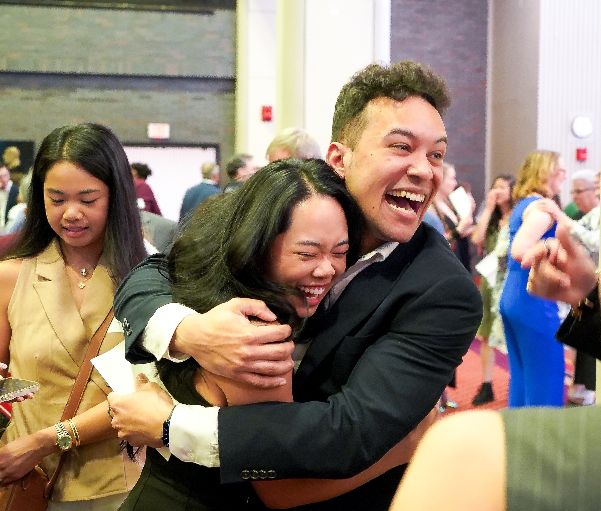 A man and woman hug after opening their Match Day letters