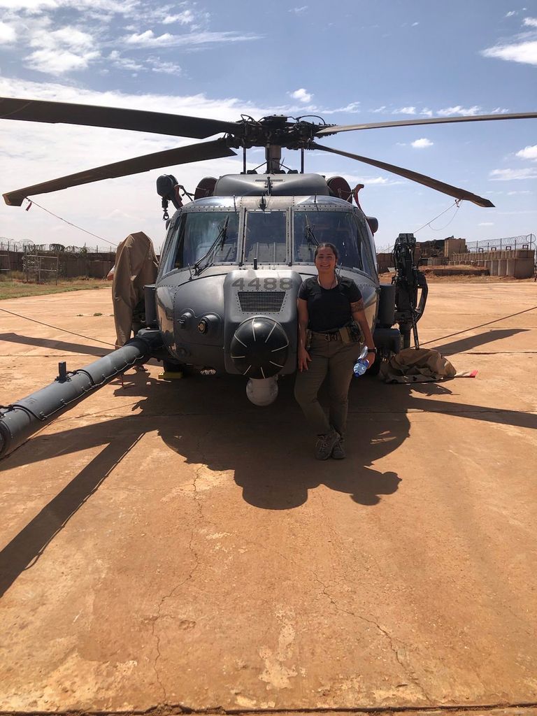 Vejar standing in front of a helicopter