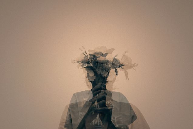 grayscale image of man holding a flower