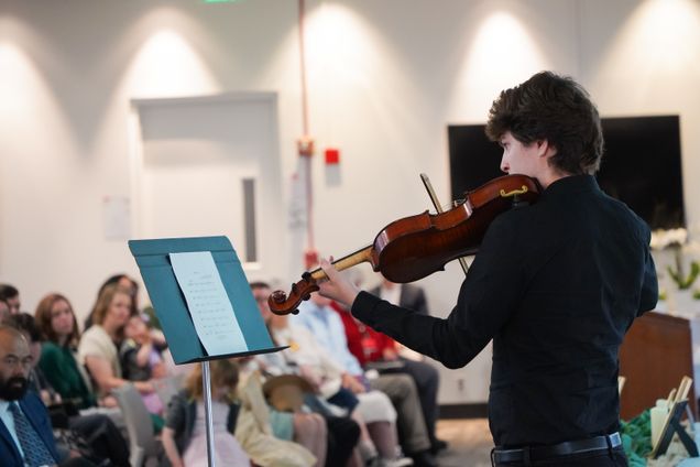man playing violin solo at ceremony
