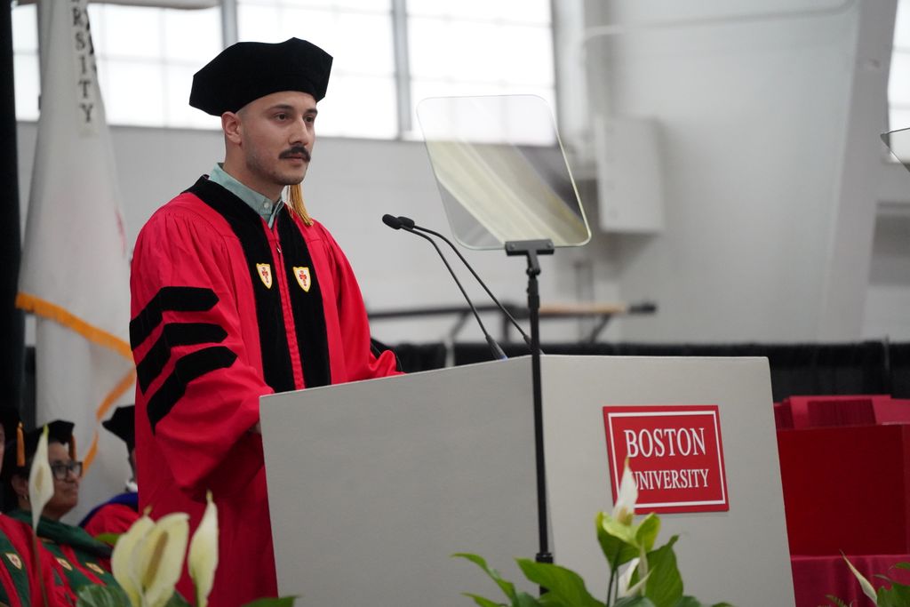 PhD speaker in regalia at podium making speech
