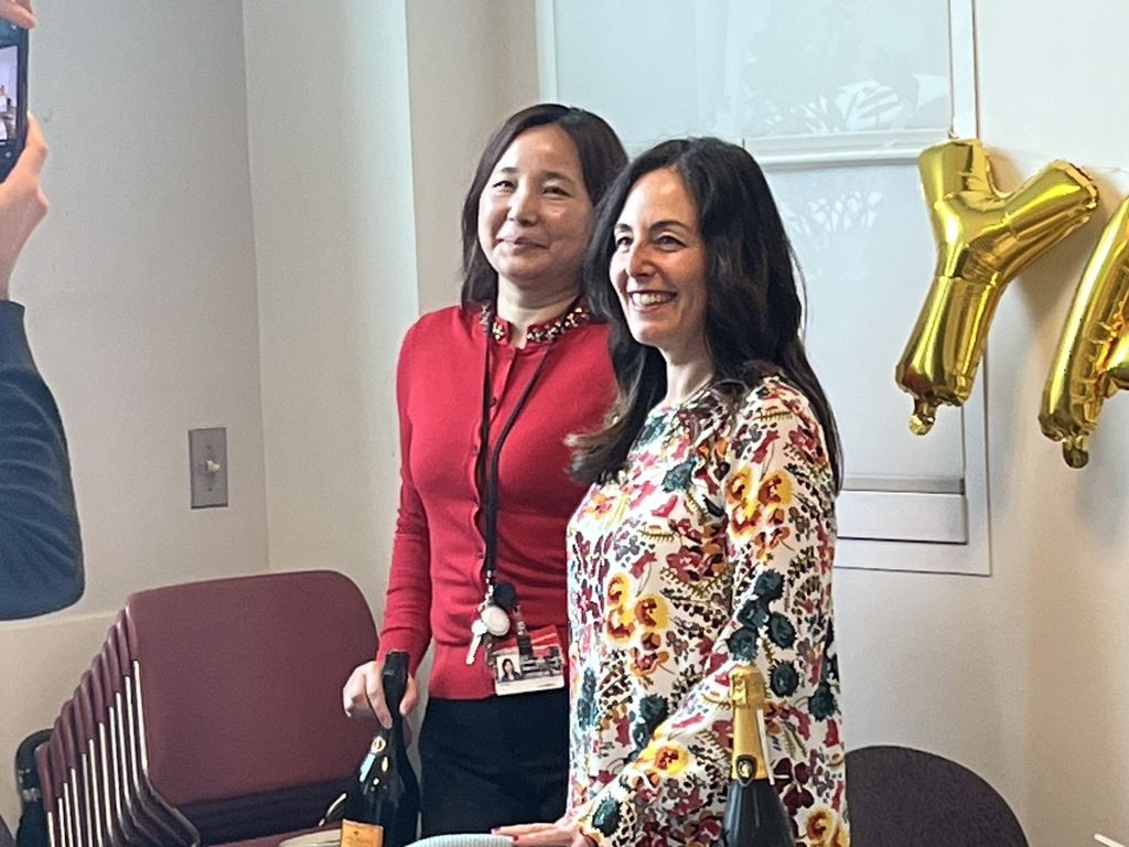 Drs. Seta and Han celebrate their grant, standing with bottle of champagne and balloons