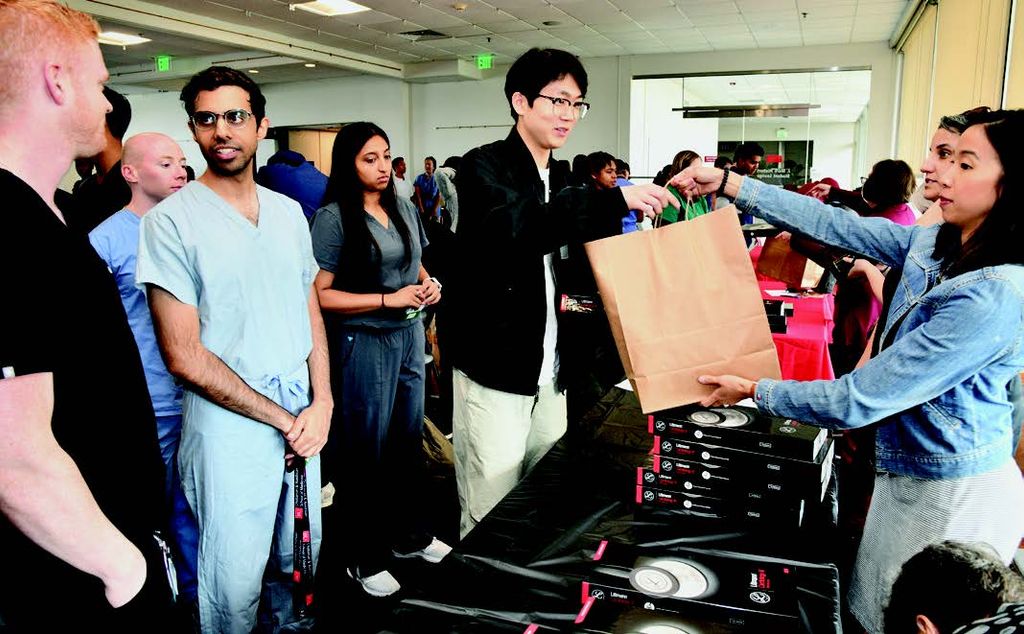 Medical student Justin Kong receives his medical equipment while Shreya Mahapatra (in blue scrubs) waits in line.