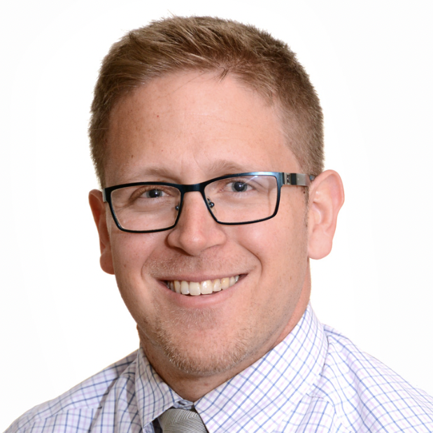 Head and shoulders image of Devin Steenkamp, wearing glasses, shirt, tie, smiling broadly