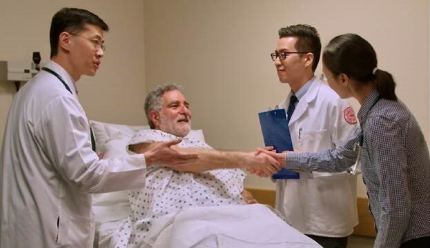 Medical doctor and students gathered around patient in bed