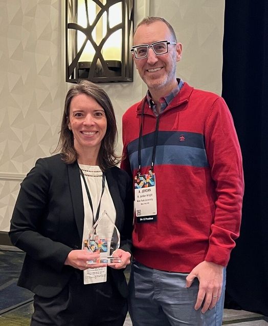Woman receiving glass award from man
