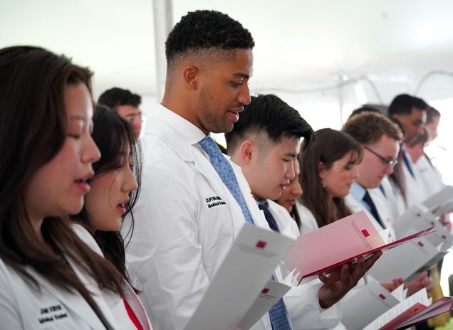Students in whitecoats read hippocratic oath