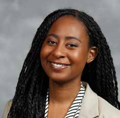 A black woman with long twists, smiling