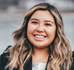 Woman with dark hair and blonde highlights smiling