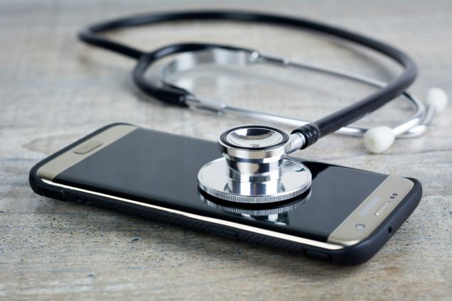 A smartphone with a stethoscope on top of it.