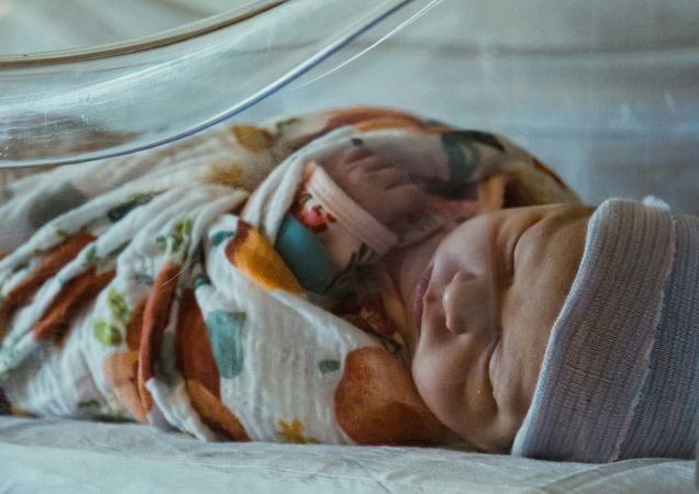 Sick baby in hospital incubator