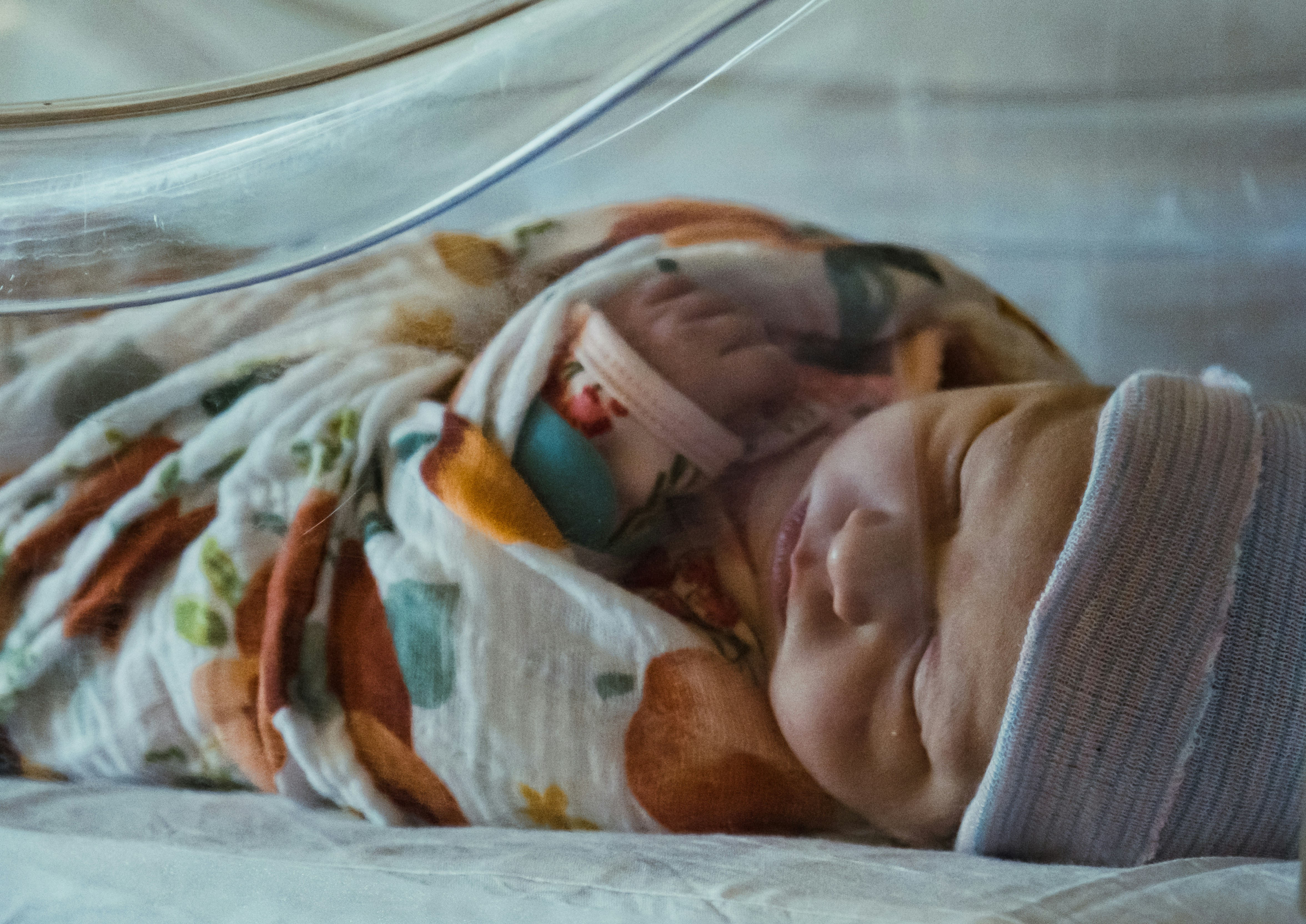 Sick baby in hospital incubator