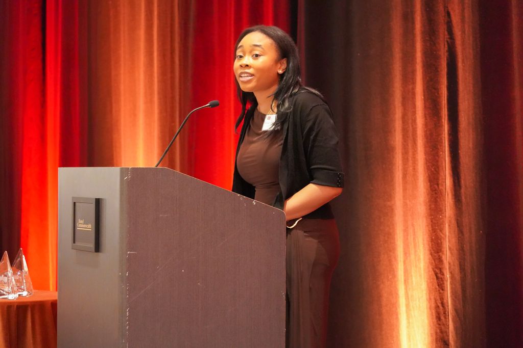 Woman standing behind podium speaking