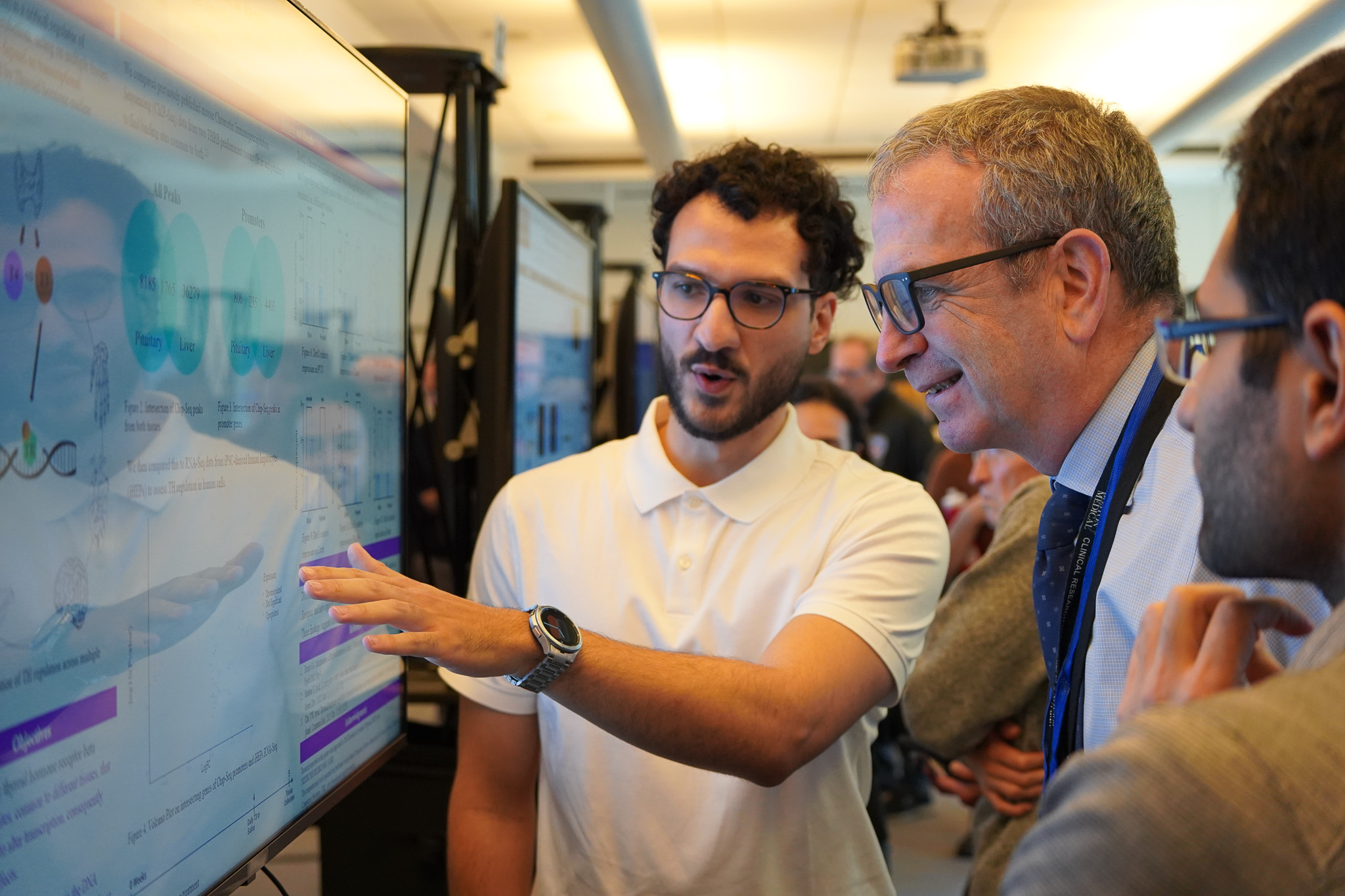 Three men looking at poster at Evans day