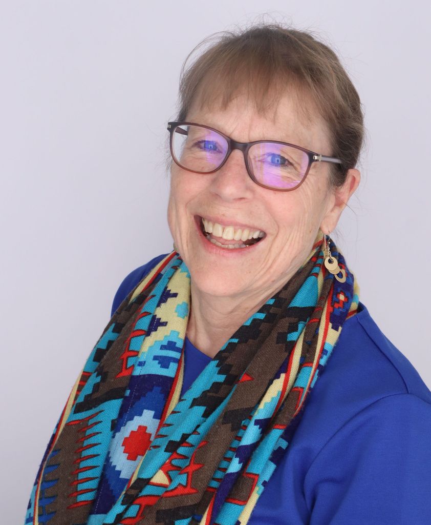 head and shoulders of Julie White wearing a blue jacket and colorful scarf