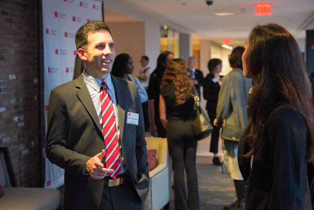 Daniel Kirshenbaum standing talking to a student