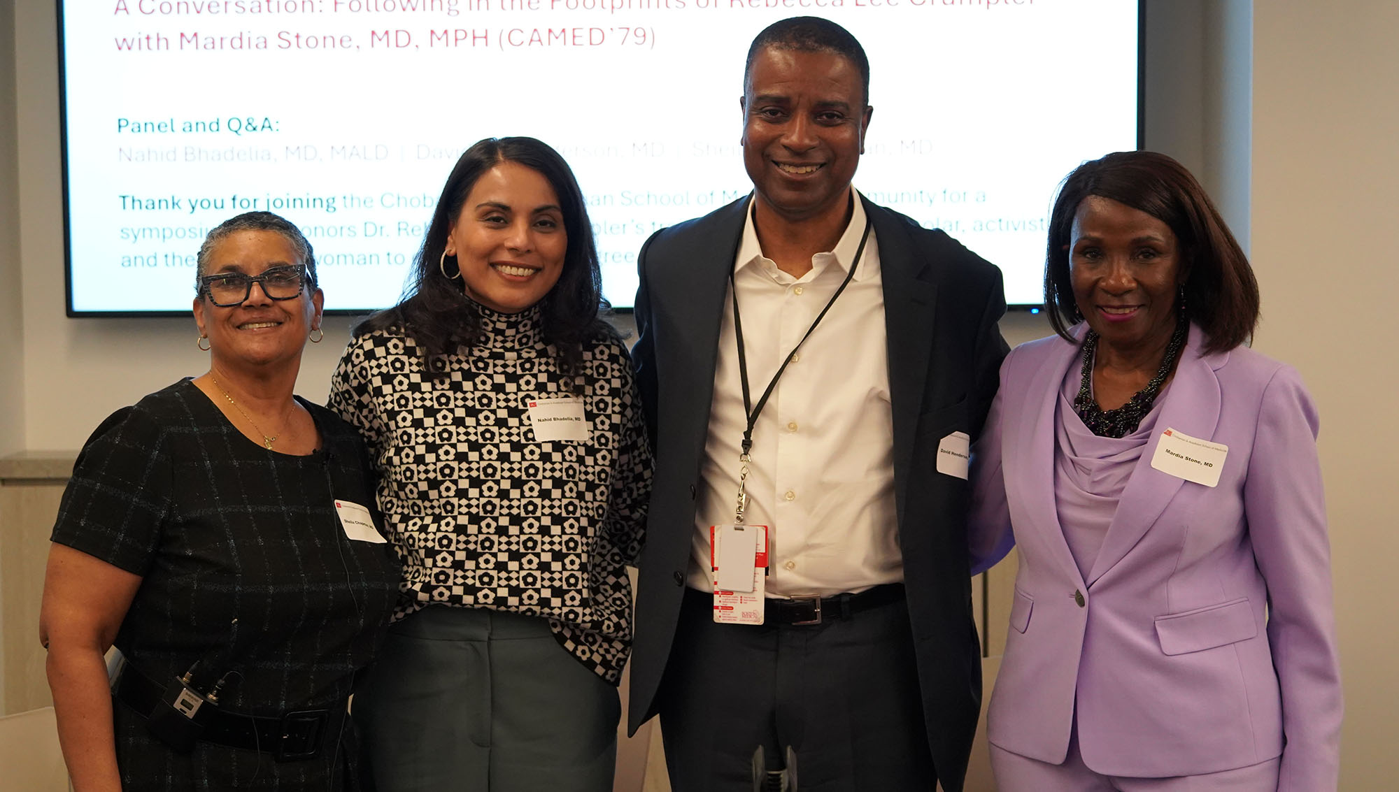 five people standing and smiling