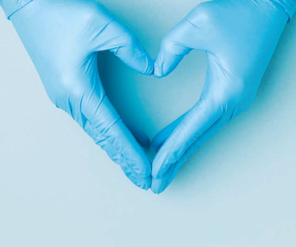 Two gloved hands make the shape of a heart, on the cover of a magazine