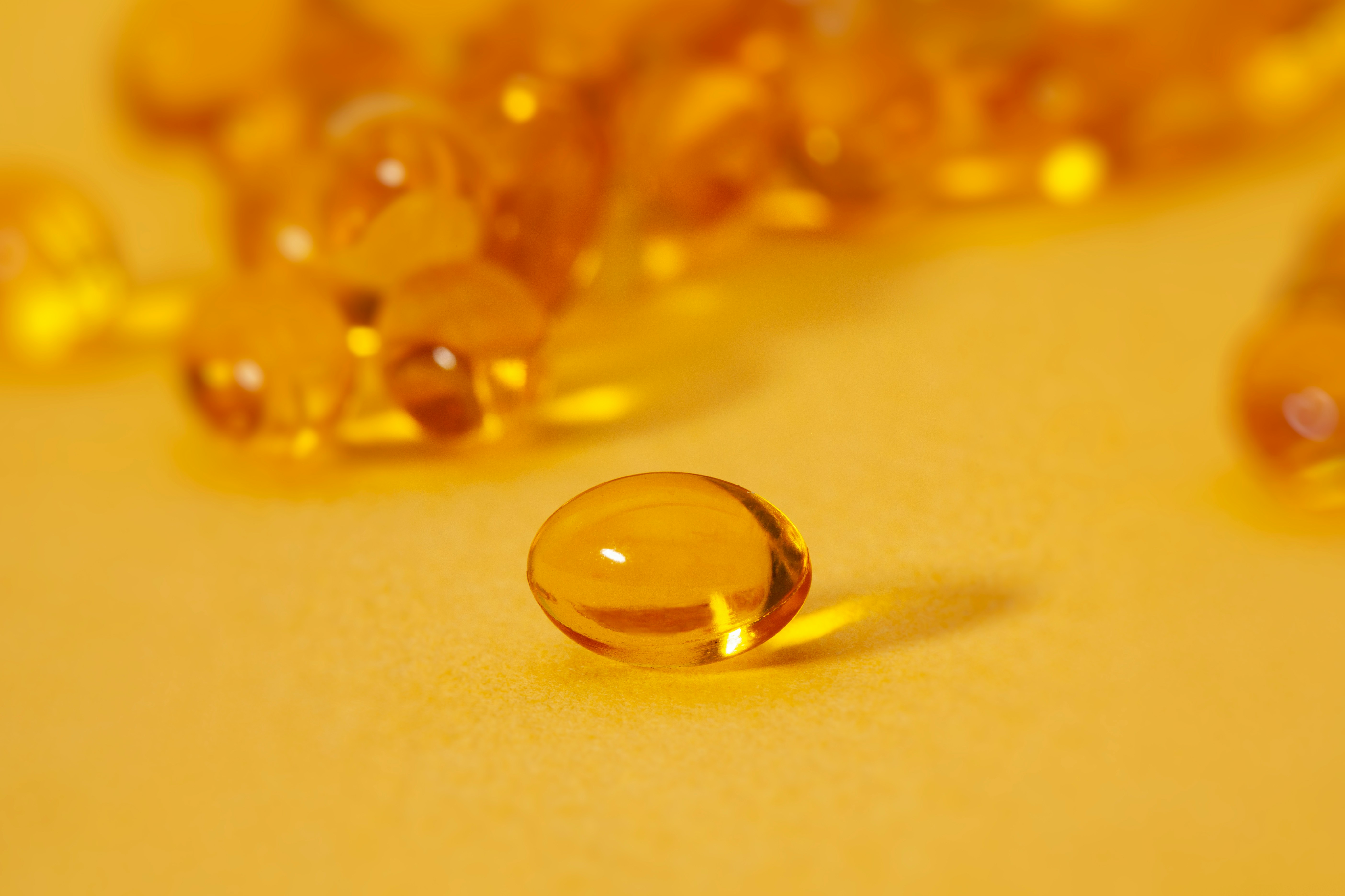 yellow vitamin d medicine against yellow background
