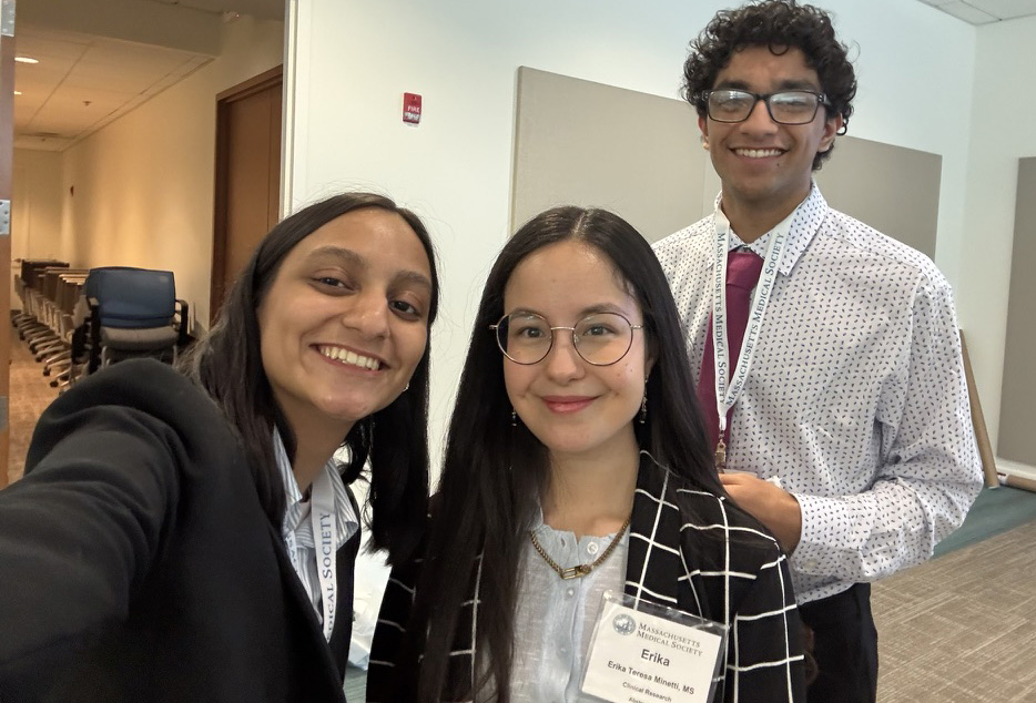 Three students in business attire smiling