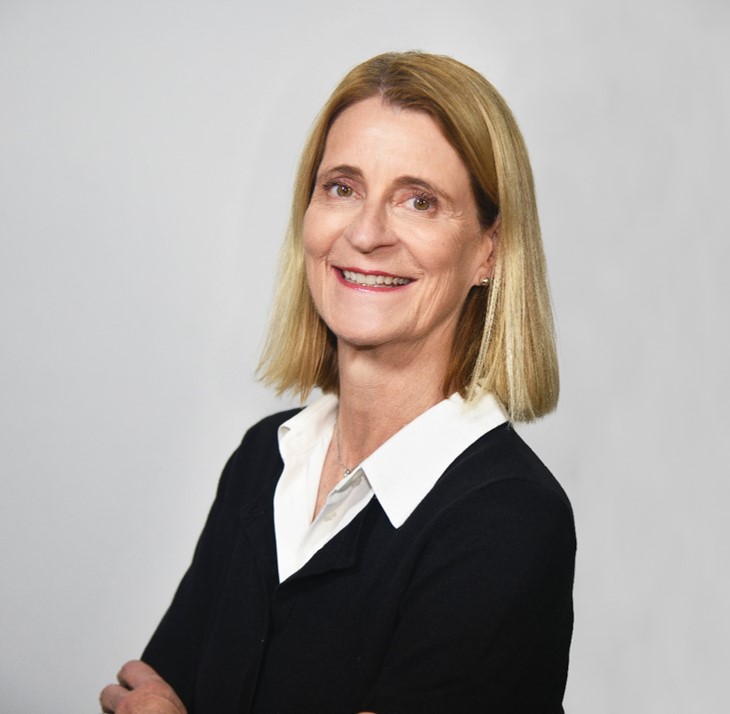 head and shoulders of Dr. Pessina, shoulder length straight blond hair, white blouse, dark sweater