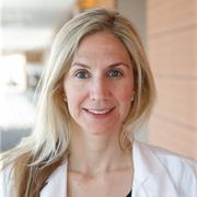 Woman with blond shoulder-length hair, wearing whitecoat, smiling