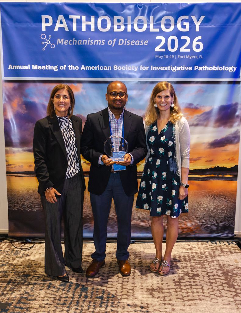 Dennis Jones Center holding award flanked by two women