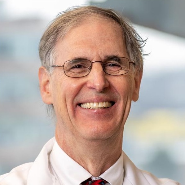 head and shoulders of man with gray hair, eyeglasses, whitecoat