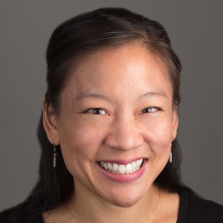 head and shoulders of woman smiling broadly with dark top