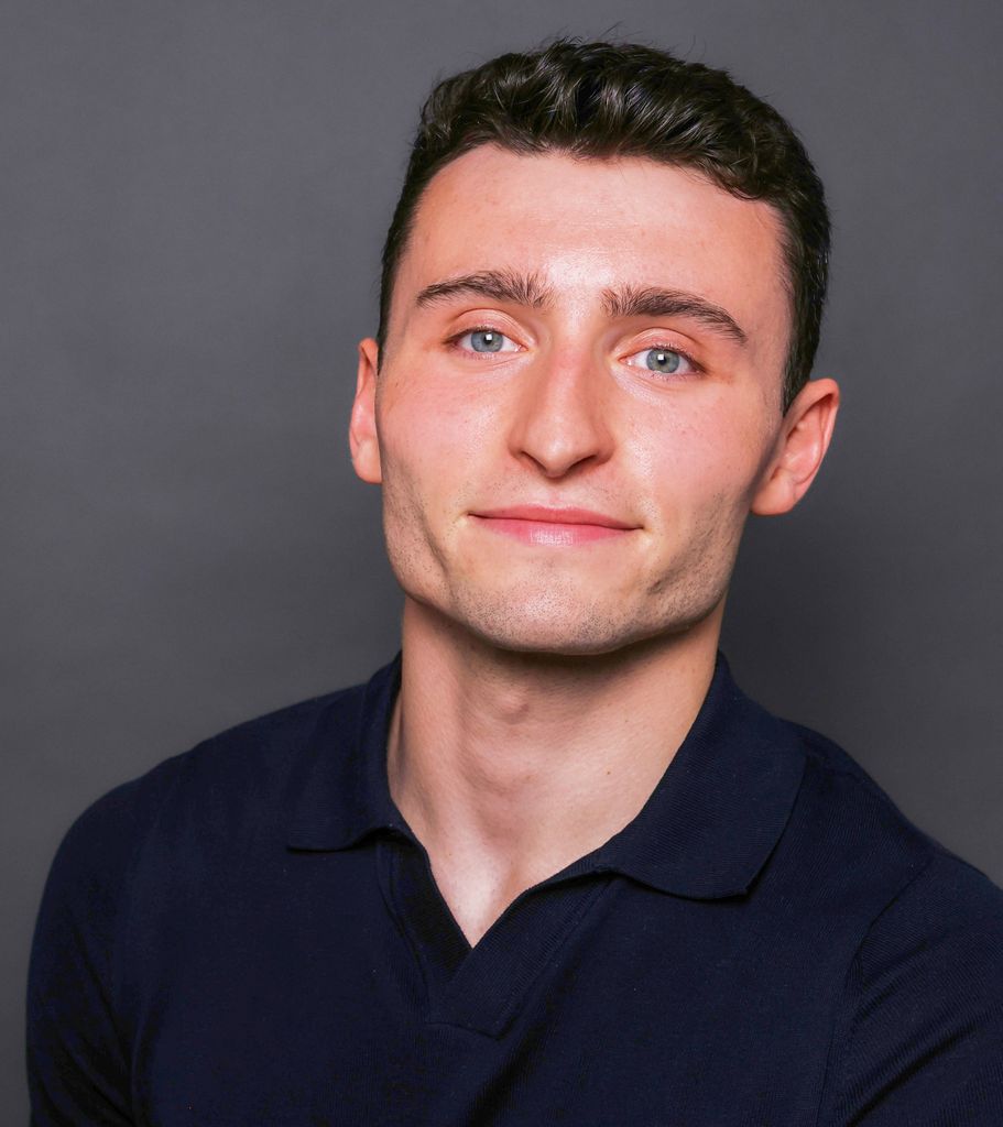 Man with dark hair wearing dark polo shirt