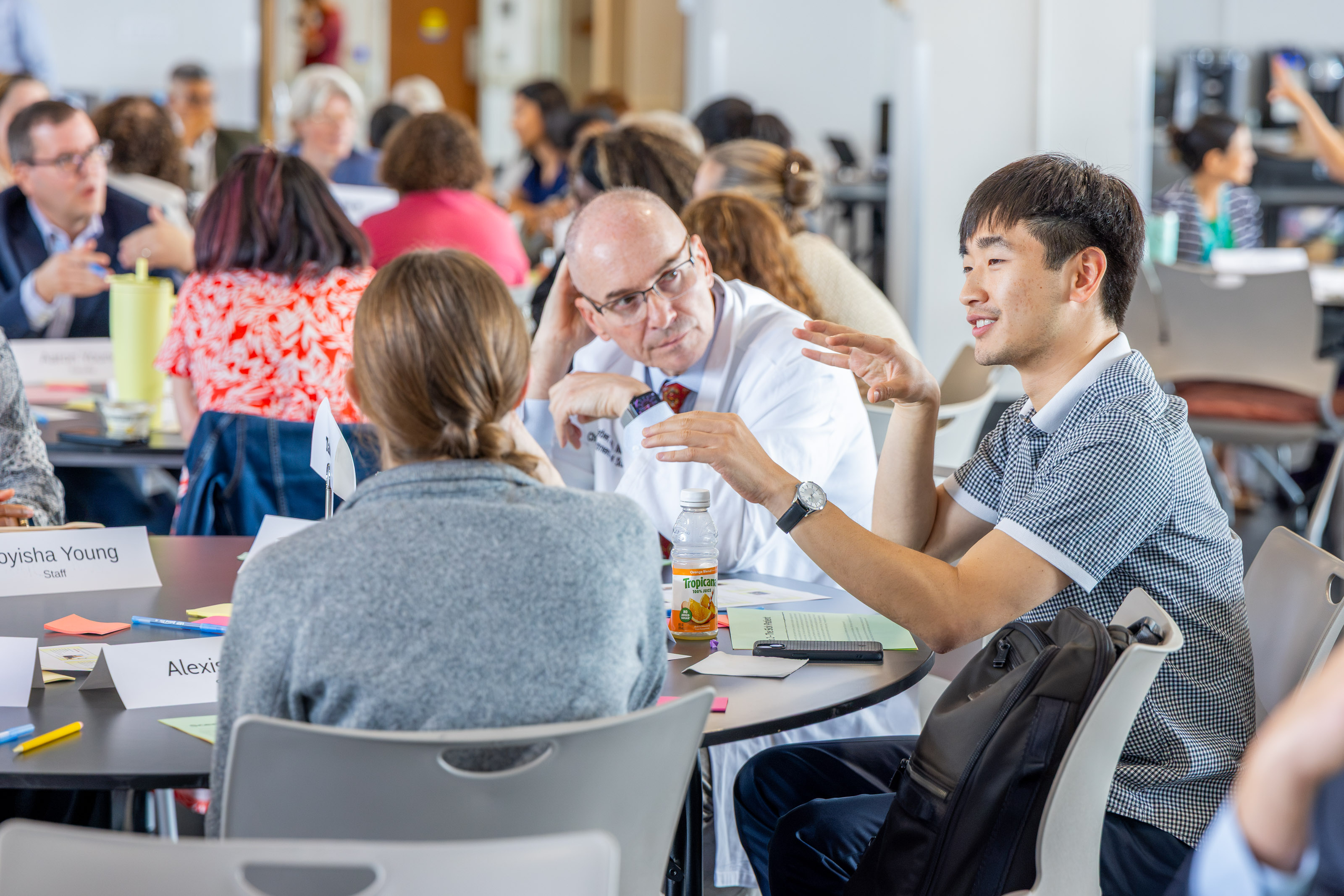 Three people sitting at a table talking