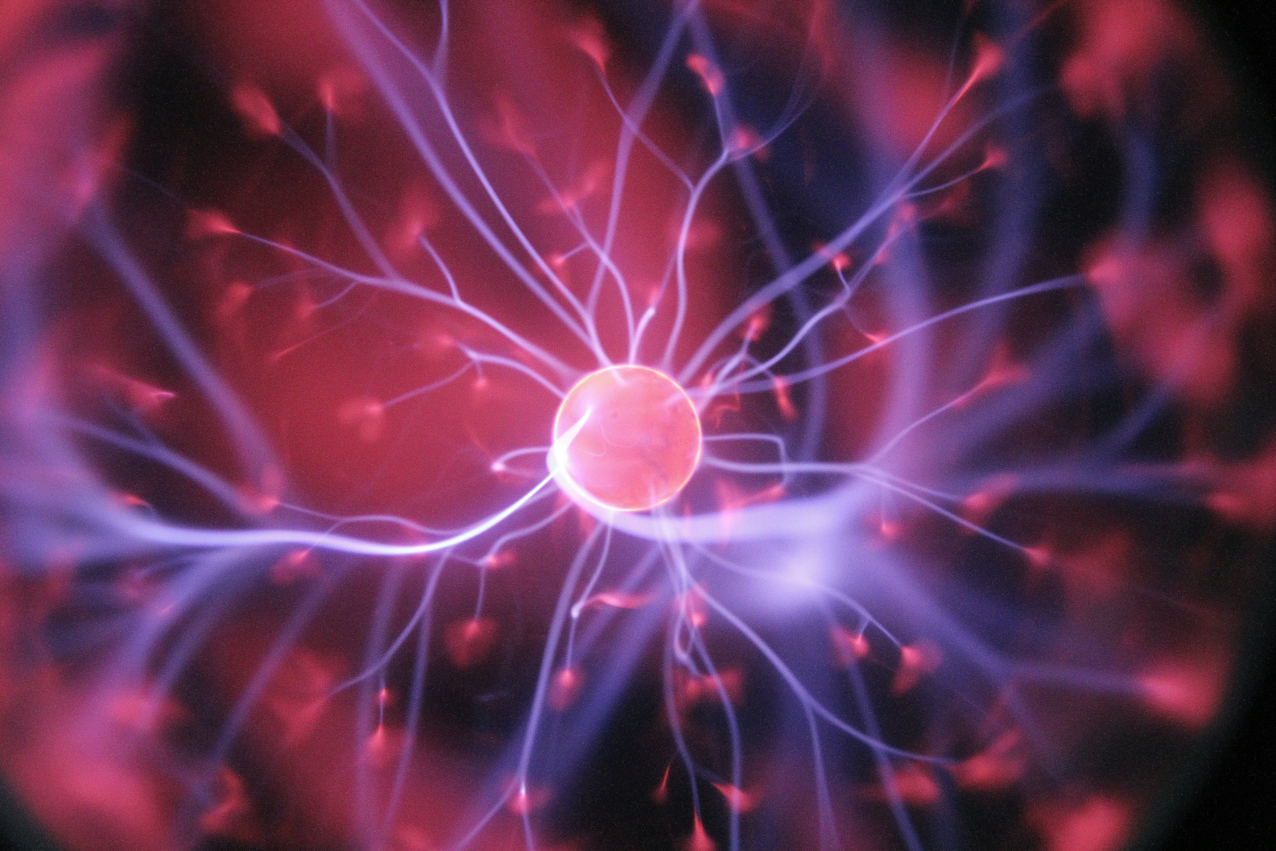 small pink orb surrounded by pruple lines and pink flecks of glowing light