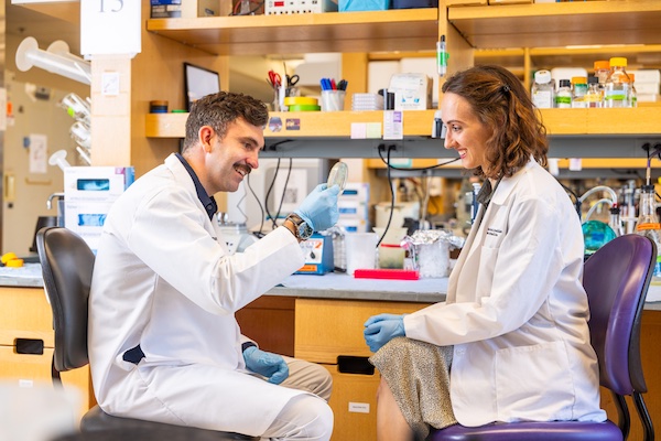 Mentor Thomas Clarke, PhD, assistant professor of pathology &  laboratory medicine, in his lab with mentee Isabelle Joy, a third-year medical student.
