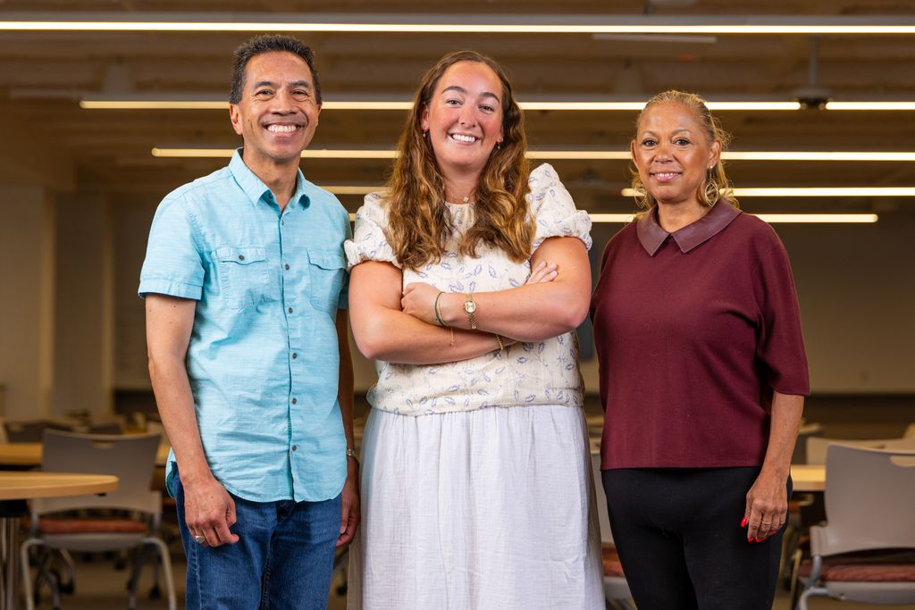 Man and two women standing  and smiling