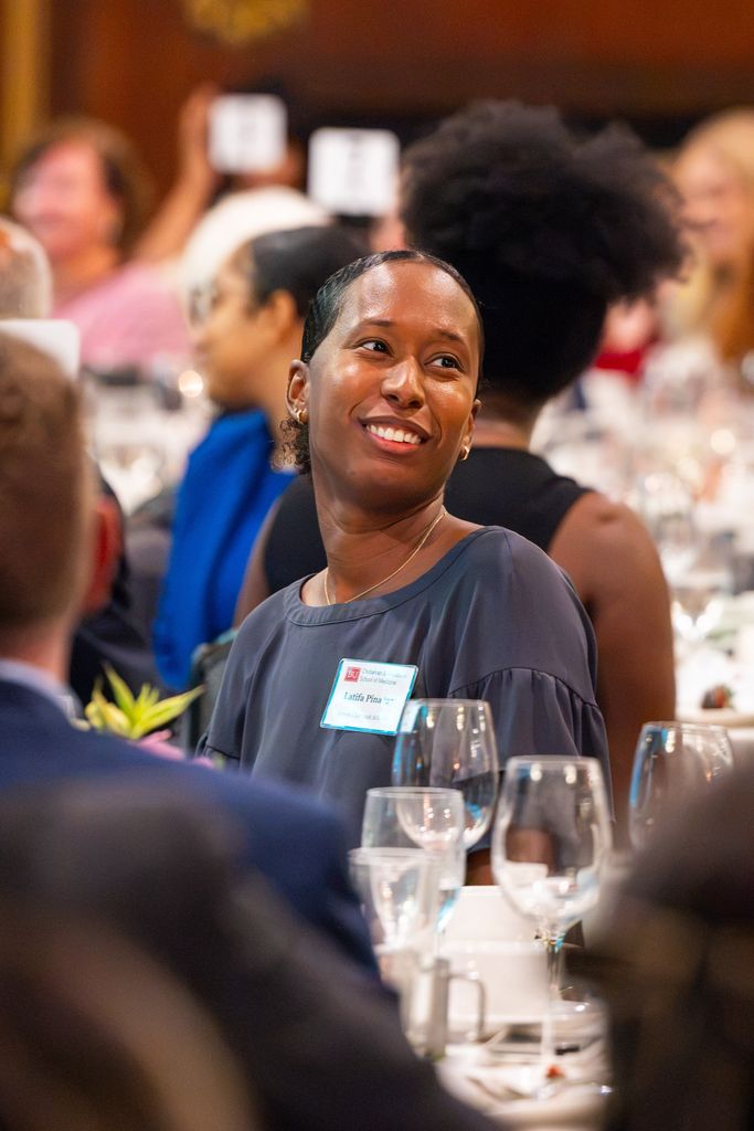 Woman at table smiling and listening to conversation